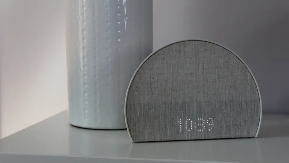 The Hatch Restore 2 sits on a nightstand, displaying the time