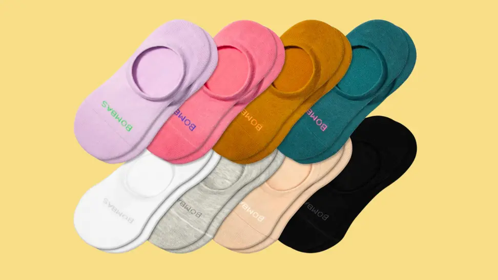 Eight pairs of Bombas socks on a yellow background