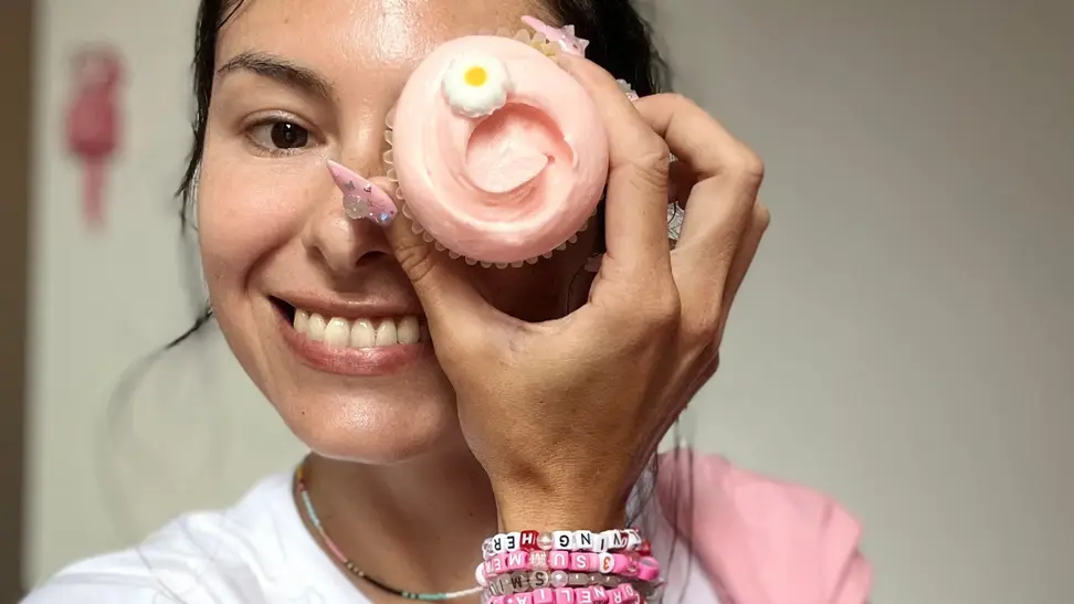The author holding a cupcake with one hand.