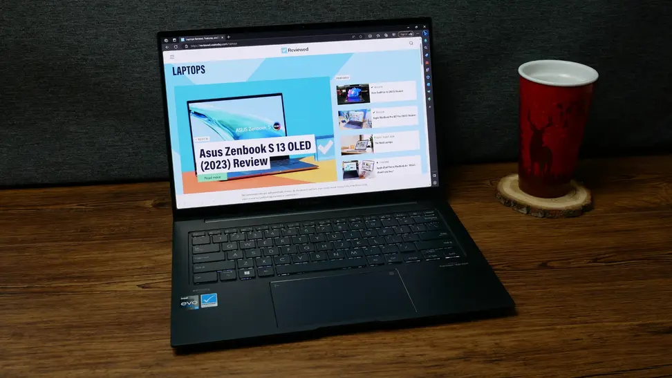 The Asus Zenbook 14x OLED displaying the front page for Reviewed.com.