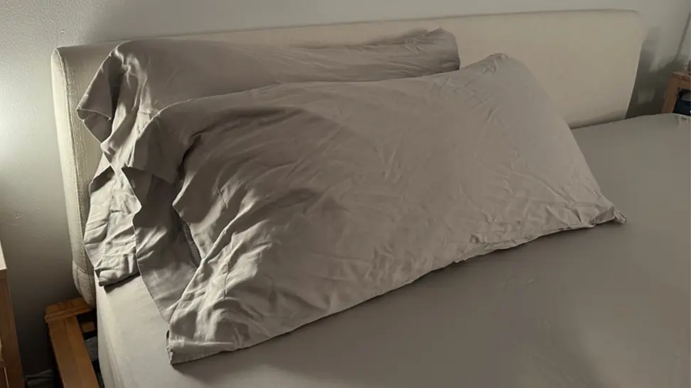A set of gray cozy earth bed sheets on a bed with two pillows in the Cozy Earth pillowcases.