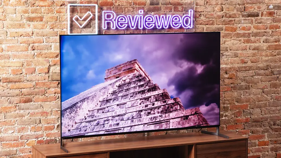 The Sony A95L QD-OLED TV on a wooden credenza displaying an ancient building.