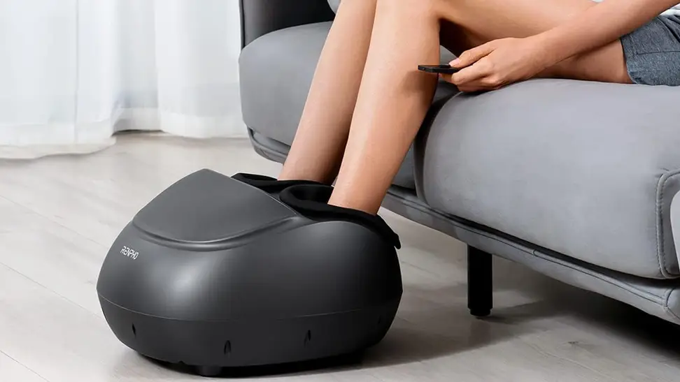 A Renpho premium foot massager being used by someone on a couch.