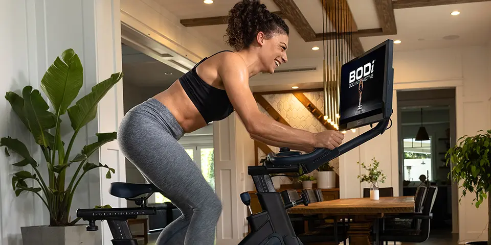 A woman using a Bodi bike in her home.