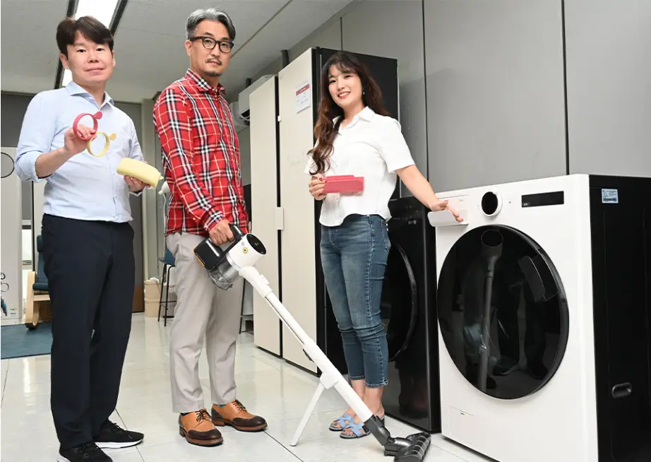 Three people standing next to the LG’s Universal Up equipment.