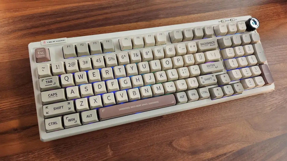 The Epomaker RT100 Mechanical Keyboard with the RGB keys on laying flat on a table.