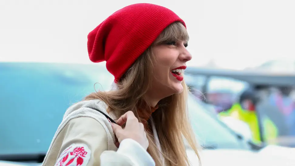 Taylor Swift in white jacket and red beanie