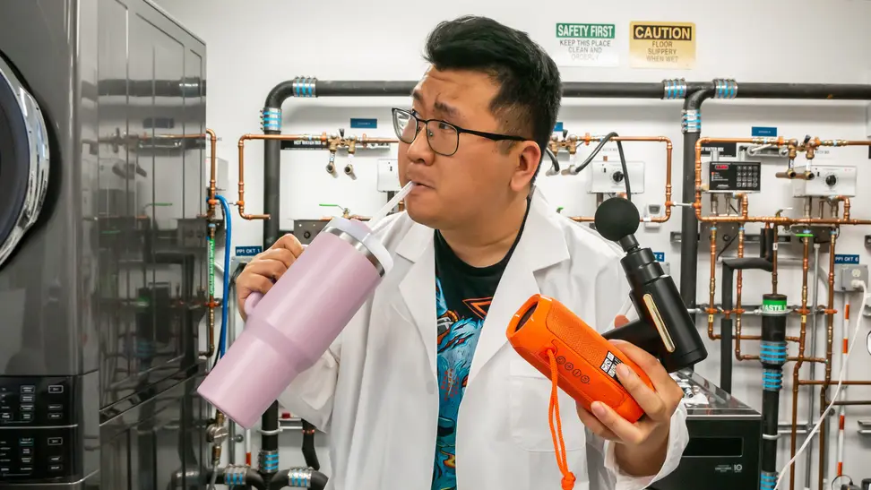 Man wearing a lab coat holding cup, massager, and speaker