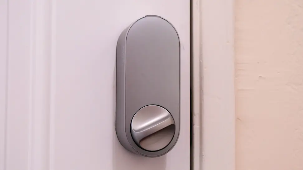 The Aqara U200 smart door lock shown in silver hanging on a white door.
