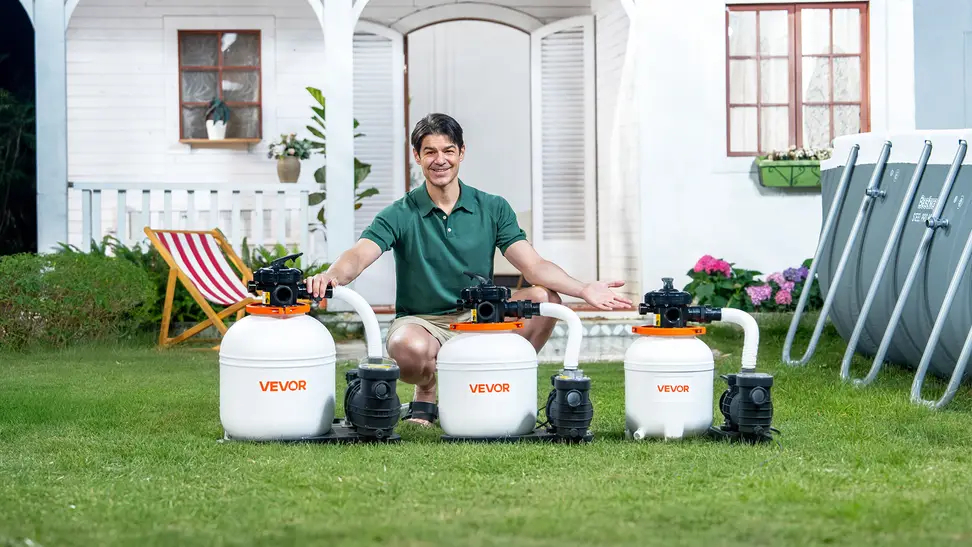Pool owner in green shirt shown squatting behind three VEVOR sand filter pumps next to an above-ground pool, on green grass in front of a white house.