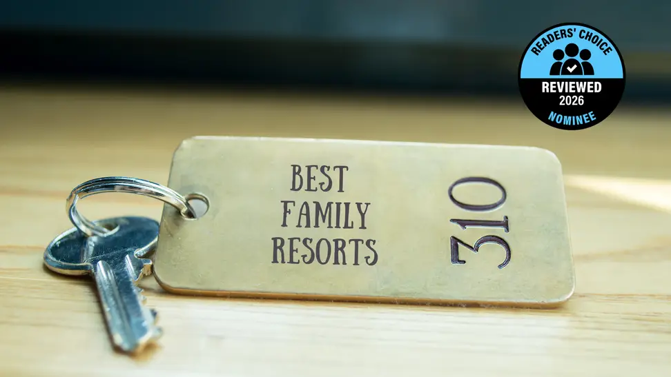 A brass hotel key with a room number on a table