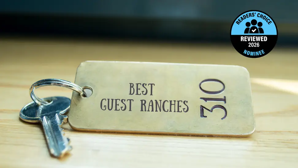 A brass hotel key with a room number on a table