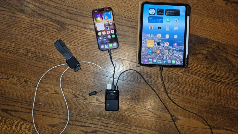 INIU Pocket Rocket 50 connected to an iPad, iPhone, and Apple Watch against a wooden surface.